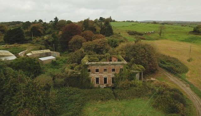 Dromdiah House Cork hidden in overgrown vegetation and trees